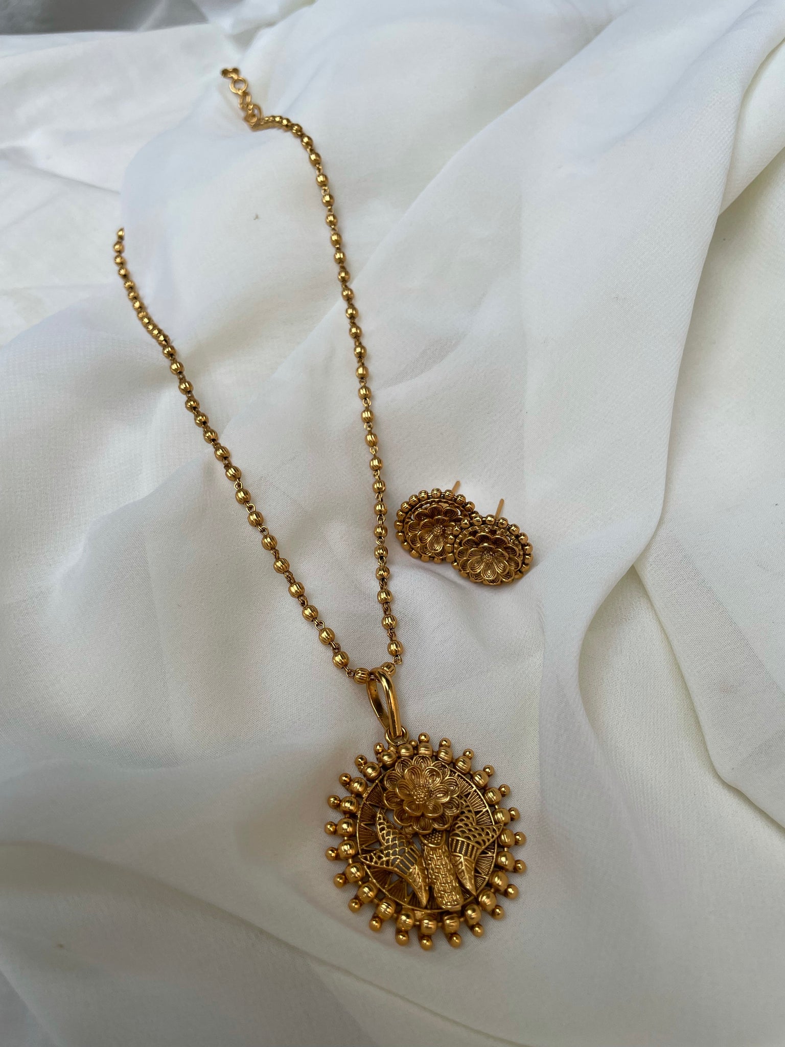 Golden flower with studs in a maala